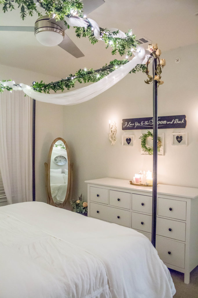 canopy bed with fairy lights on top and white dresser