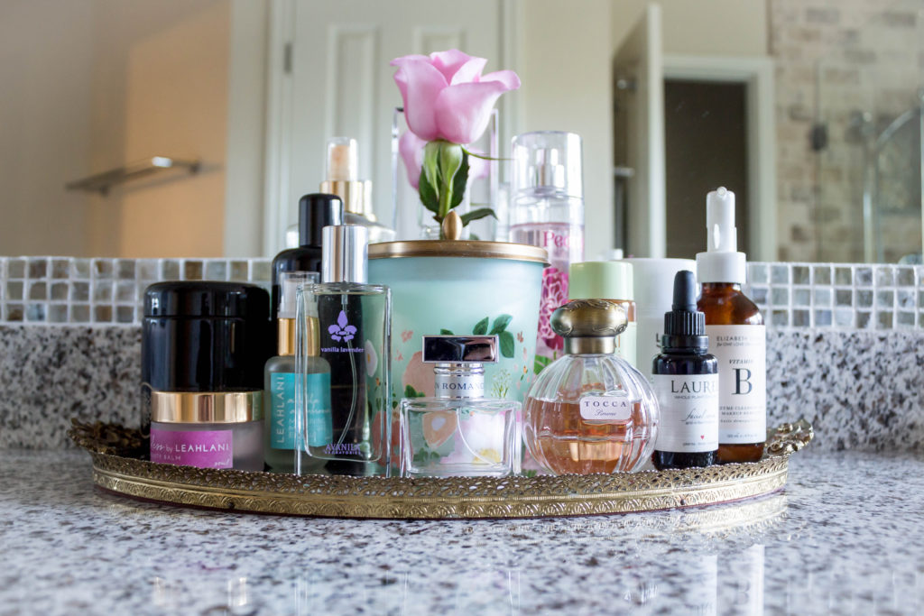 gold vanity tray with skincare and perfume in master bathroom