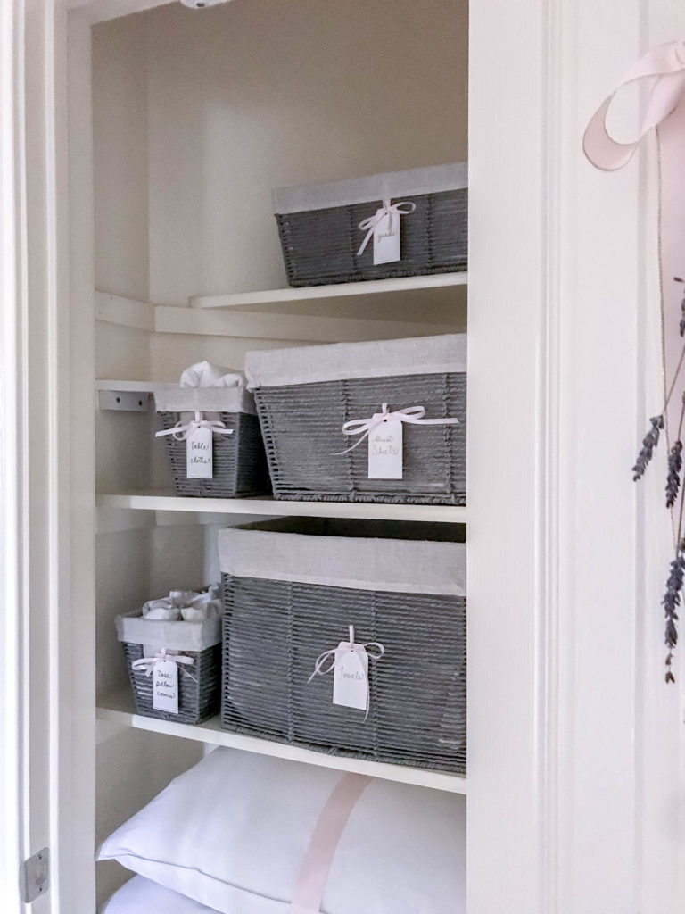 inside view of linen closet with grey baskets