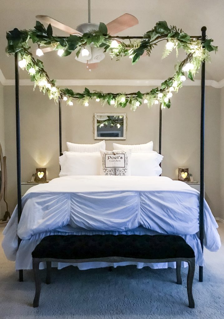 night time view of canopy bed with garlands and fairy lights on top