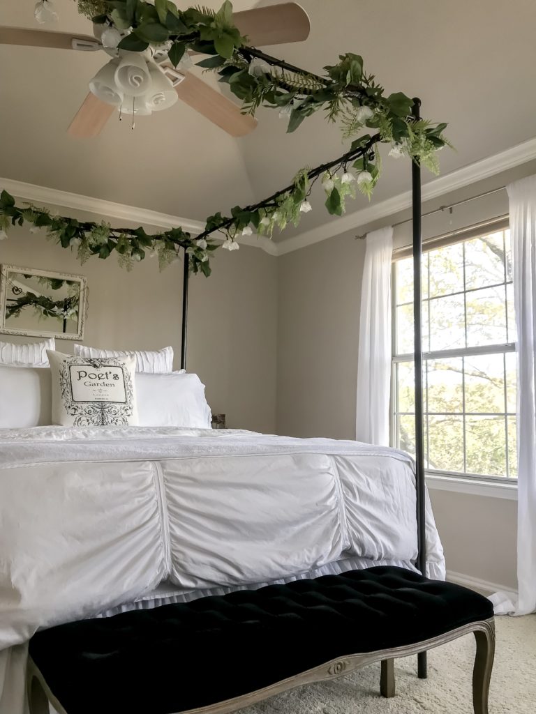 Canopy bed with garlands and view of bedroom window