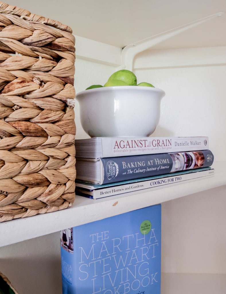 cookbooks stacked and bowl of limes on top