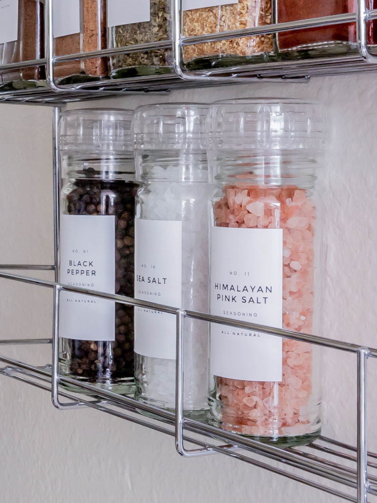 close up shot of black pepper, sea salt and pink salt grinders