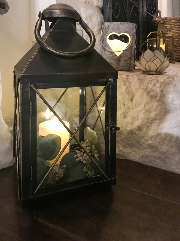 black iron lantern with candle and faux greenery inside