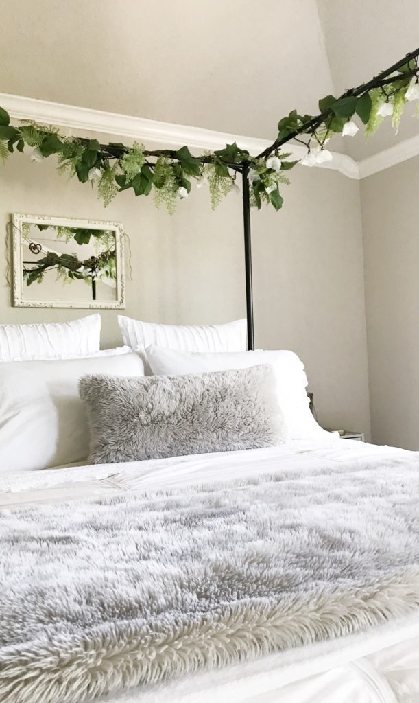 canopy bed with greenery on it and light grey faux fur pillows on bed for my fall tour